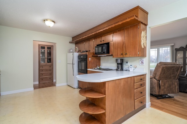 1001 Alexander St, Crookston, MN 56716 - kitchen with open shelves, light countertops, black appliances, open floor plan, and light floors