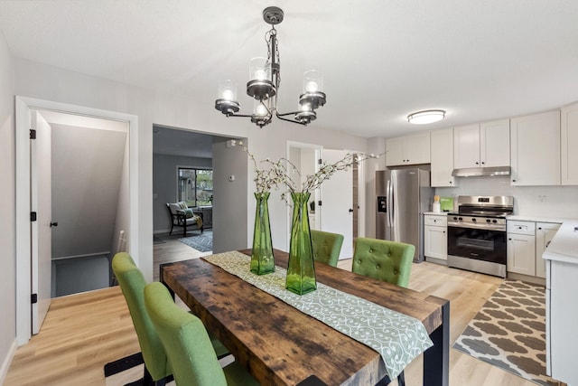 dining space featuring an inviting chandelier and light wood-style flooring