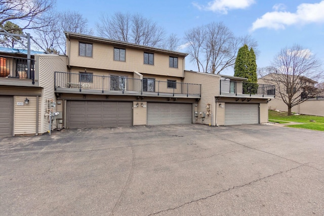 view of front of home featuring an attached garage and a balcony