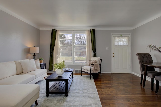 living area with wood finished floors, visible vents, and baseboards