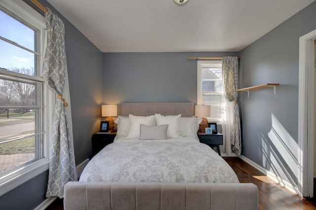 bedroom with baseboards and dark wood-type flooring