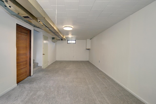 below grade area with light colored carpet and stairway