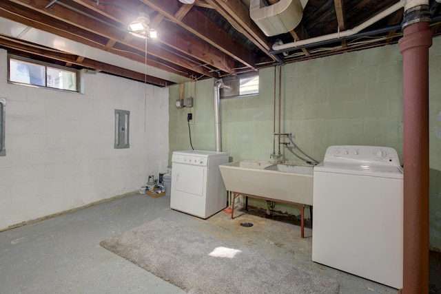 washroom featuring washing machine and clothes dryer, electric panel, laundry area, and a sink
