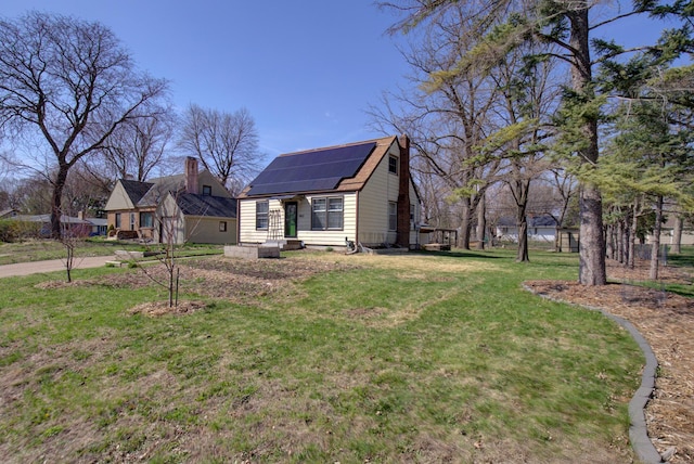 view of side of property featuring solar panels and a yard