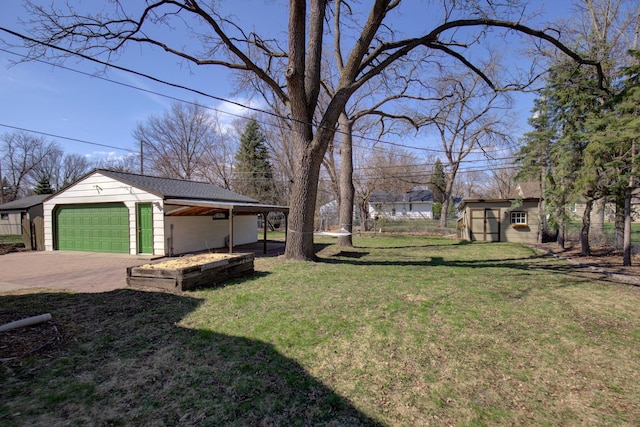view of yard featuring driveway, an outdoor structure, and a garage