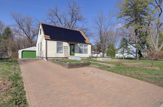 view of front of property featuring an outdoor structure and a detached garage