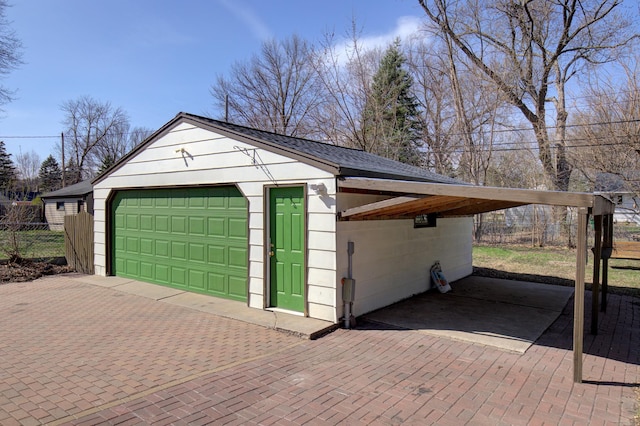 garage featuring fence and a detached garage