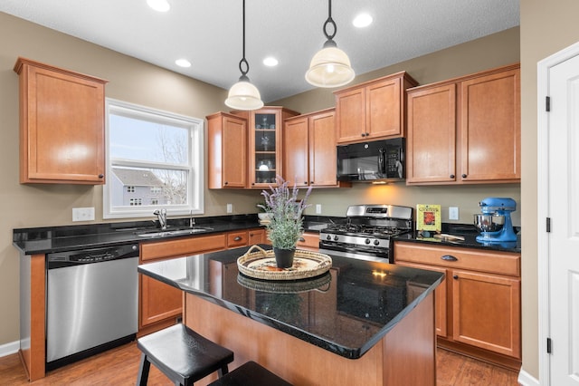 4584 Merganser Dr, Minnetrista, MN 55375 - kitchen featuring a sink, a breakfast bar, light wood-type flooring, stainless steel appliances, and decorative light fixtures