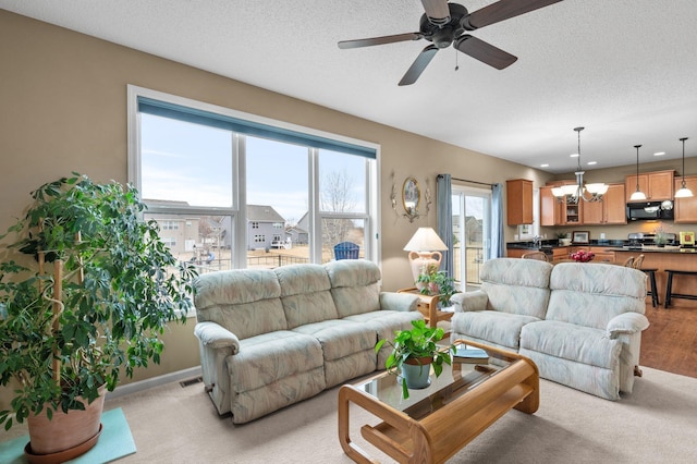 4584 Merganser Dr, Minnetrista, MN 55375 - living room with visible vents, a textured ceiling, light colored carpet, and ceiling fan with notable chandelier