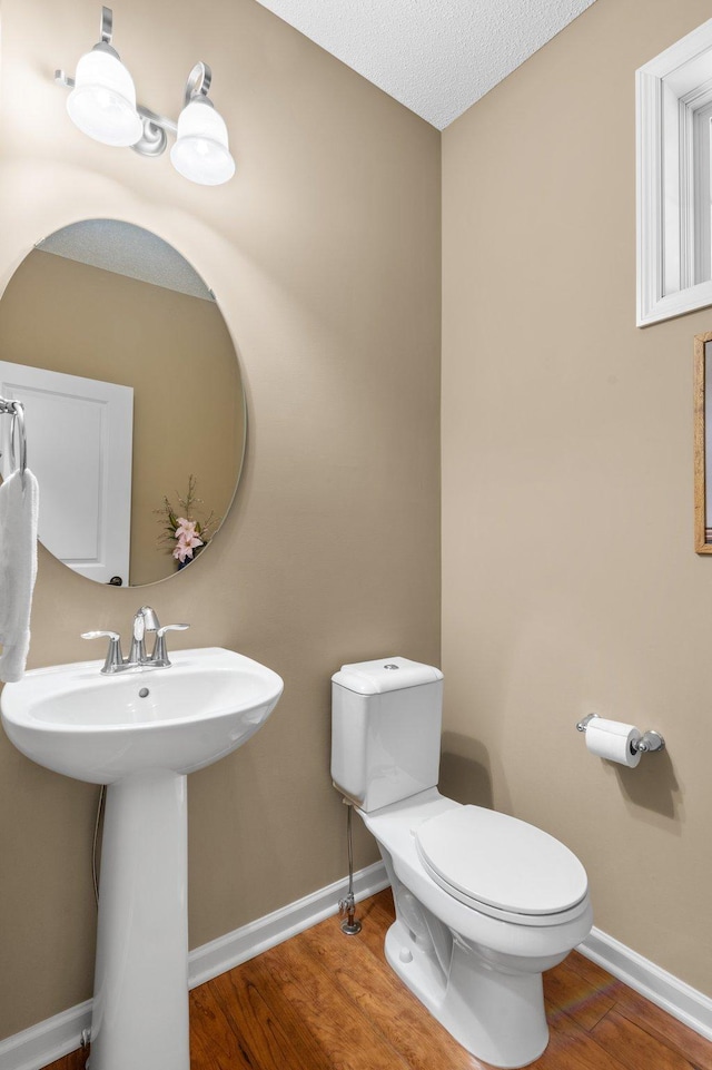 4584 Merganser Dr, Minnetrista, MN 55375 - half bath featuring a sink, toilet, wood finished floors, and baseboards