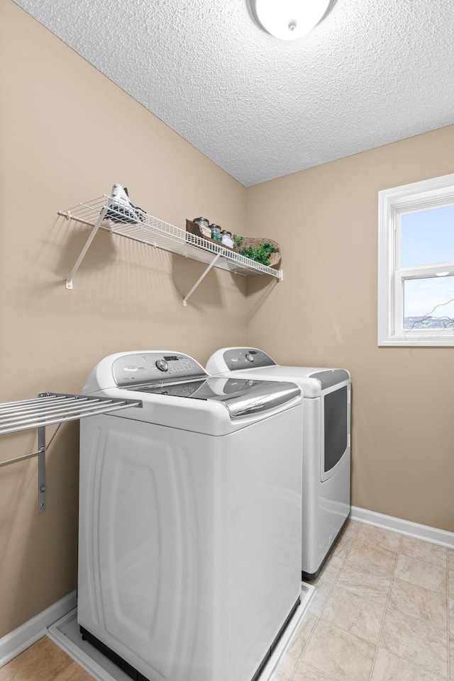 4584 Merganser Dr, Minnetrista, MN 55375 - clothes washing area with washer and dryer, baseboards, a textured ceiling, and laundry area