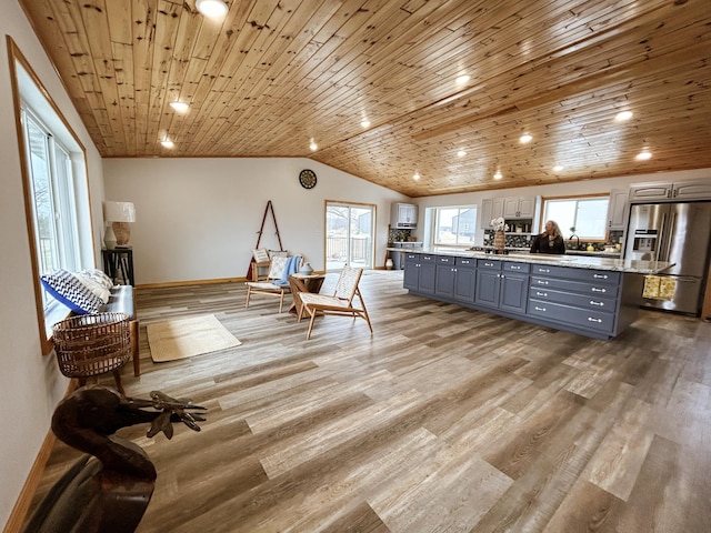 41634 Long Lake Rd, Ottertail, MN 56571 - kitchen with stainless steel refrigerator with ice dispenser, gray cabinets, vaulted ceiling, a center island, and light wood-style floors