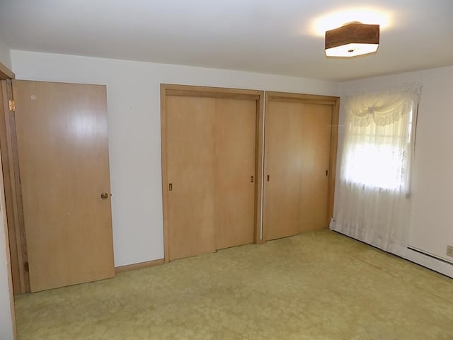 unfurnished bedroom featuring two closets and light carpet