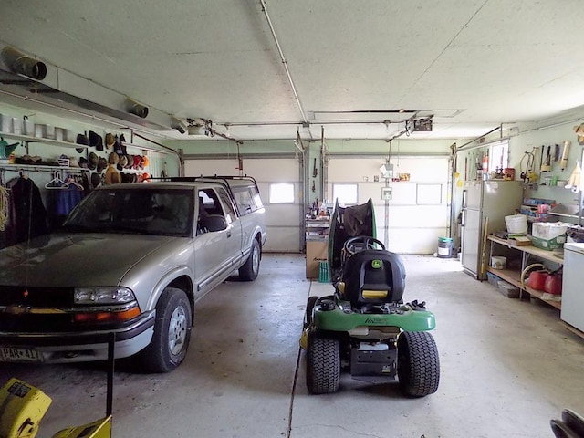 garage featuring freestanding refrigerator and a garage door opener