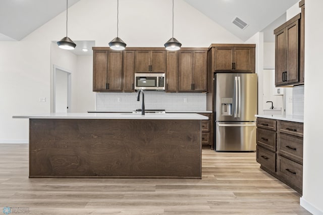 4242 Bristlecone Loop S, Fargo, ND 58104 - kitchen with stainless steel appliances, light wood finished floors, light countertops, dark brown cabinetry, and high vaulted ceiling