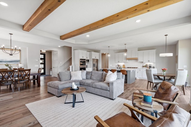 living area with beam ceiling, stairs, recessed lighting, and light wood-style floors