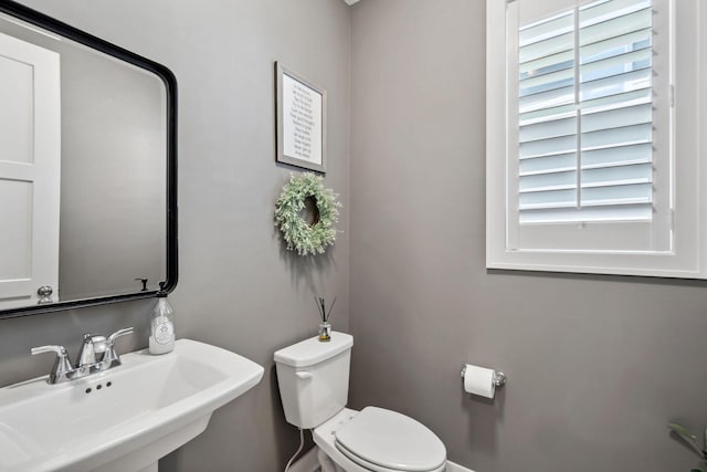 half bath featuring toilet and a sink