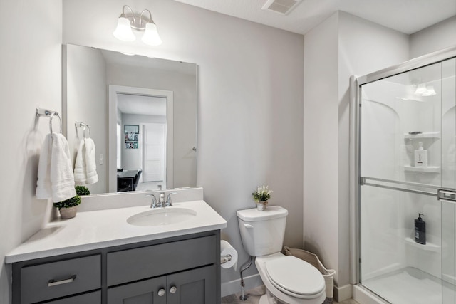 full bathroom featuring toilet, a stall shower, visible vents, baseboards, and vanity