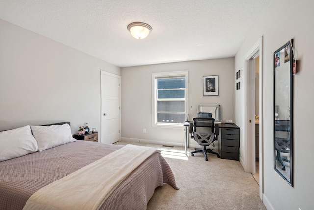 carpeted bedroom with a textured ceiling and baseboards
