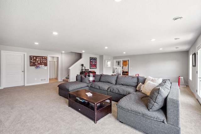 living area featuring stairway, light colored carpet, visible vents, and recessed lighting