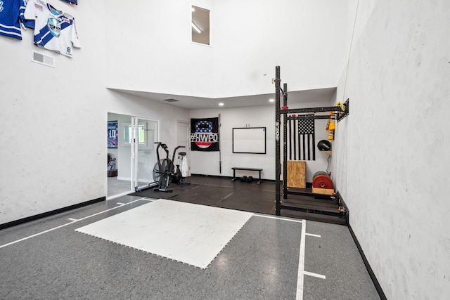 interior space with a towering ceiling, baseboards, and visible vents