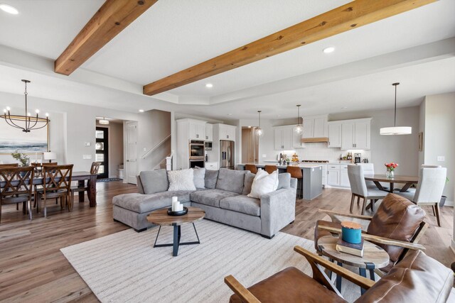 10683 40th St N, Lake Elmo, MN 55042 - living room featuring beamed ceiling, light wood finished floors, stairs, recessed lighting, and a chandelier