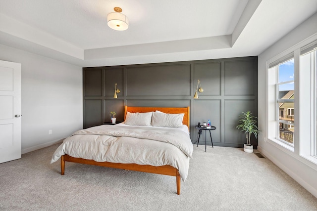 10683 40th St N, Lake Elmo, MN 55042 - bedroom featuring light carpet, a decorative wall, a raised ceiling, and baseboards
