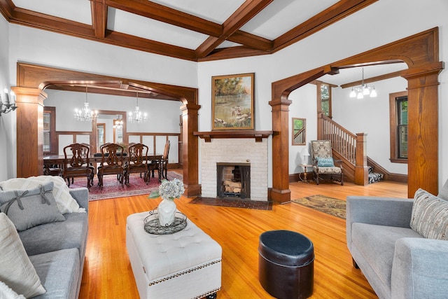 904 Lincoln Ave, Saint Paul, MN 55105 - living room featuring a chandelier, beamed ceiling, coffered ceiling, decorative columns, and wood finished floors
