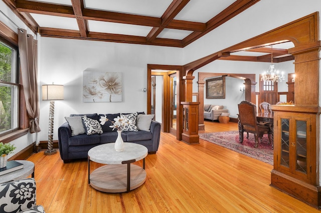 904 Lincoln Ave, Saint Paul, MN 55105 - living room with ornate columns, a chandelier, coffered ceiling, beamed ceiling, and light wood-style flooring