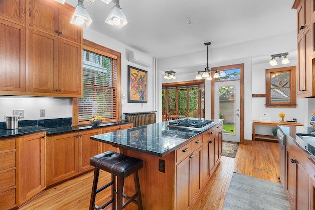 904 Lincoln Ave, Saint Paul, MN 55105 - kitchen featuring stainless steel gas stovetop, light wood-type flooring, brown cabinetry, and a kitchen island
