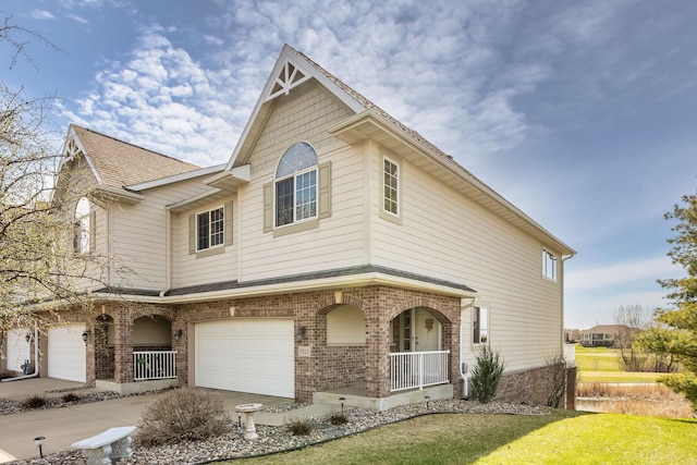 view of front facade featuring a porch, brick siding, driveway, and a garage