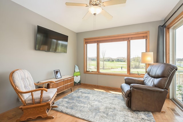 sitting room with visible vents, wood finished floors, and a healthy amount of sunlight