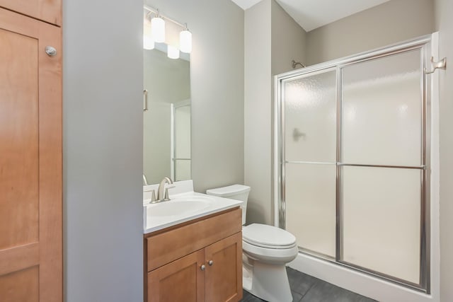 bathroom with toilet, a shower stall, tile patterned flooring, and vanity