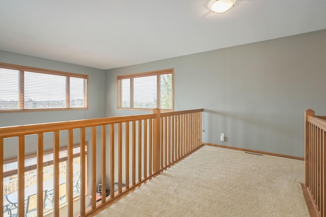 corridor with carpet flooring, baseboards, and visible vents