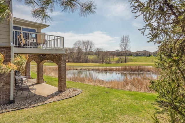 view of yard with a water view and a patio area