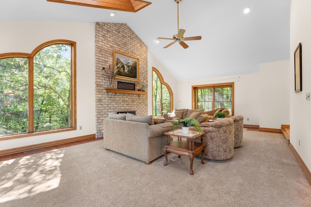 living area with a ceiling fan, a brick fireplace, baseboards, carpet, and high vaulted ceiling