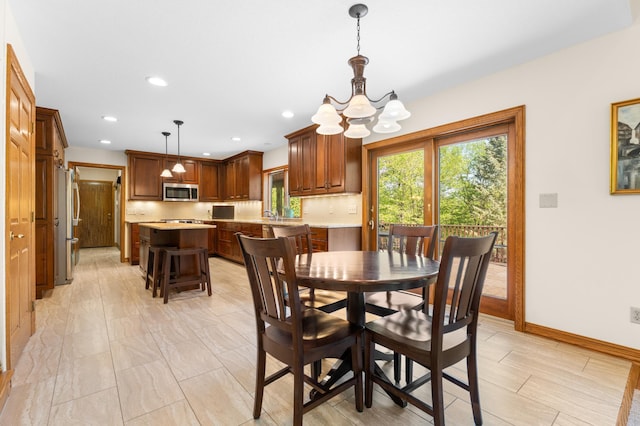 dining space with a chandelier, baseboards, and recessed lighting