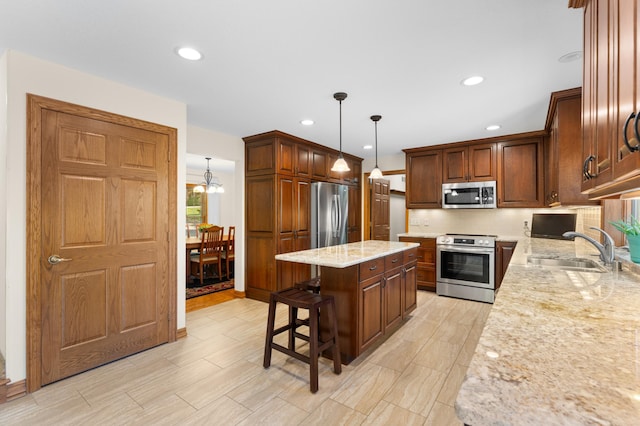 kitchen featuring stainless steel appliances, a kitchen island, tasteful backsplash, a sink, and light stone countertops