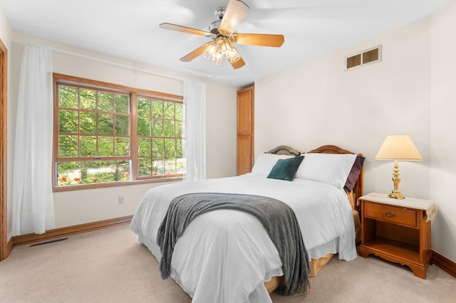 bedroom featuring light colored carpet, baseboards, and a ceiling fan