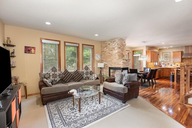 living area with recessed lighting, a fireplace, baseboards, and light carpet