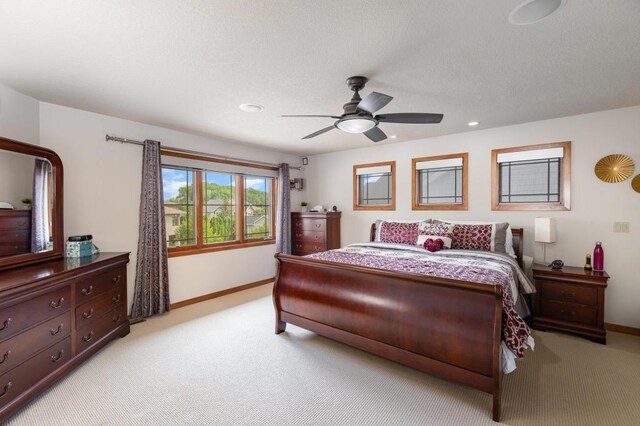 bedroom with light colored carpet, baseboards, and a ceiling fan