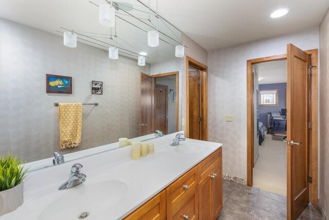 bathroom featuring connected bathroom, a sink, and double vanity