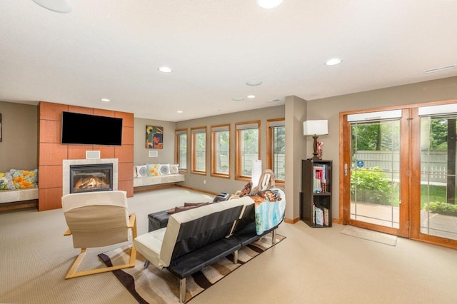 living room featuring a tiled fireplace, baseboards, carpet flooring, and recessed lighting