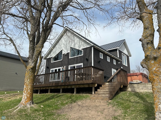 rear view of house featuring a yard, a deck, and metal roof
