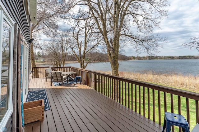 wooden terrace with a lawn and a water view