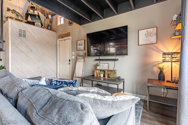 living area featuring baseboards, visible vents, and wood finished floors