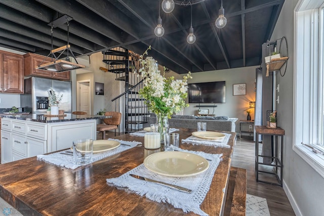 dining room featuring dark wood-style flooring, baseboards, and stairway