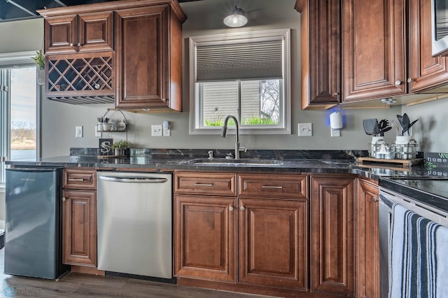 kitchen with dark wood-style flooring, stainless steel appliances, plenty of natural light, and a sink