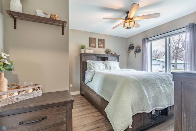 bedroom with light wood-style floors, baseboards, and ceiling fan