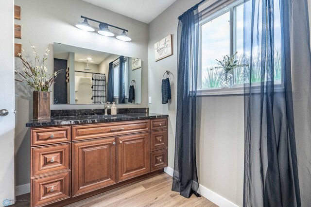 bathroom with baseboards, vanity, and wood finished floors